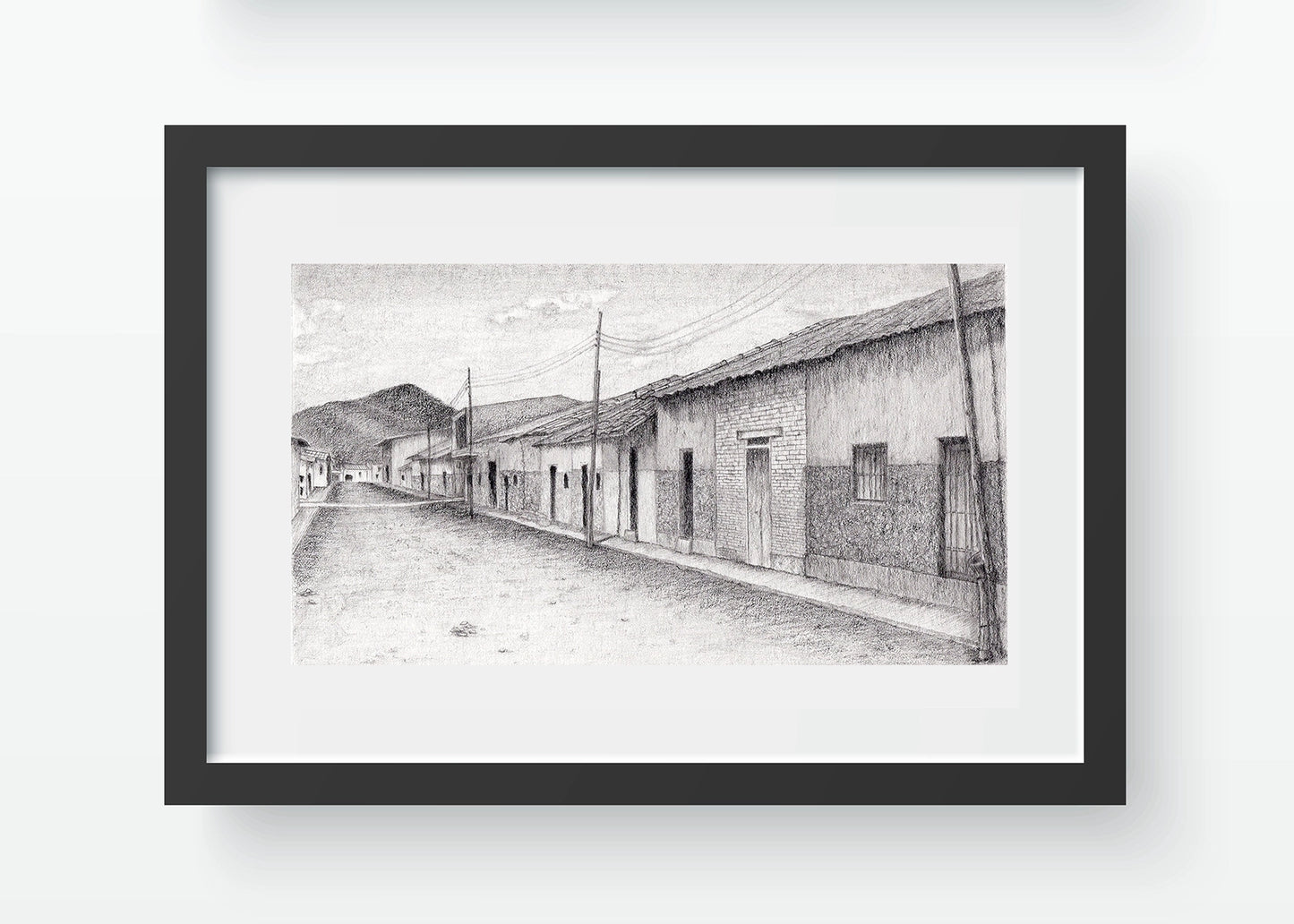 Mockup de una calle en Motupe, Lambayeque. Imagen digital del dibujo en grafito, simulando enmarcado en negro con paspartú blanco.